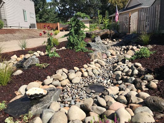Dry creek bed landscaping with river rocks